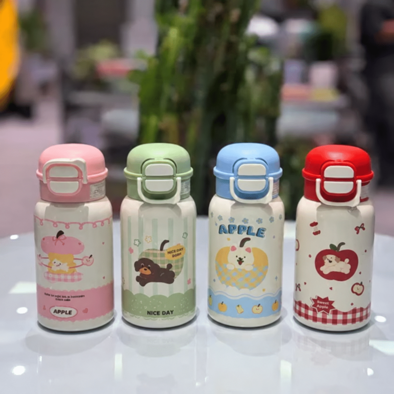 Four pastel bottles on reflective tabletop تراول تپل دوحالته 500 میل - تصویر 1